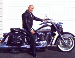 Man in black riding leathers sitting on a large motorcycle